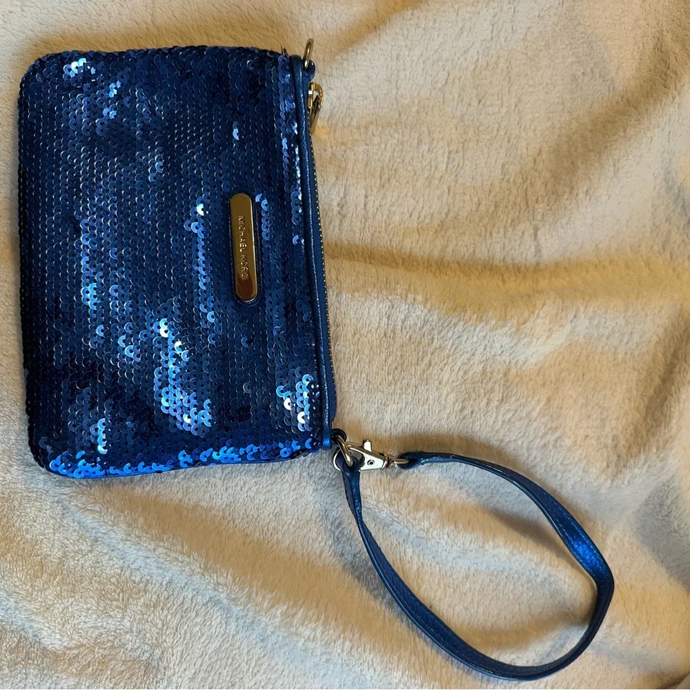 Michael Kors sapphire blue sequined wristlet with gold colored hardware.